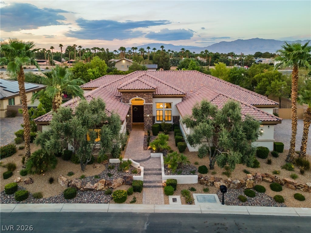 8030 Palm Cove Court, Las Vegas, NV 89129 Striking desert landscaping frames the elegant tiled roofline of this sprawling single-story residence.
