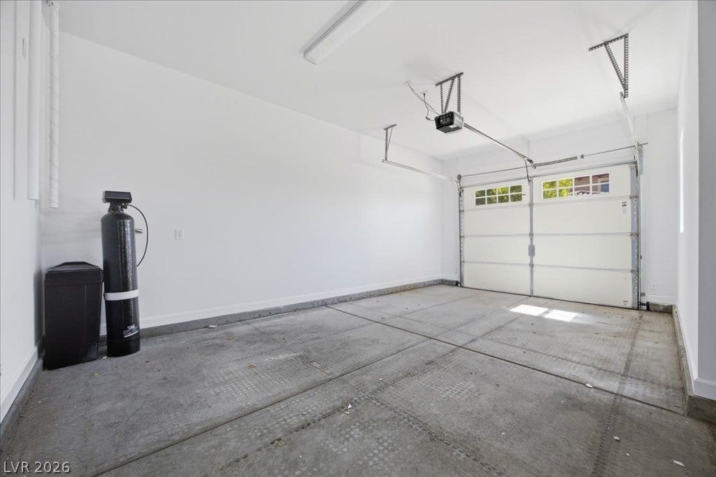 8030 Palm Cove Court, Las Vegas, NV 89129 An attached garage features durable concrete flooring and an automatic overhead door.