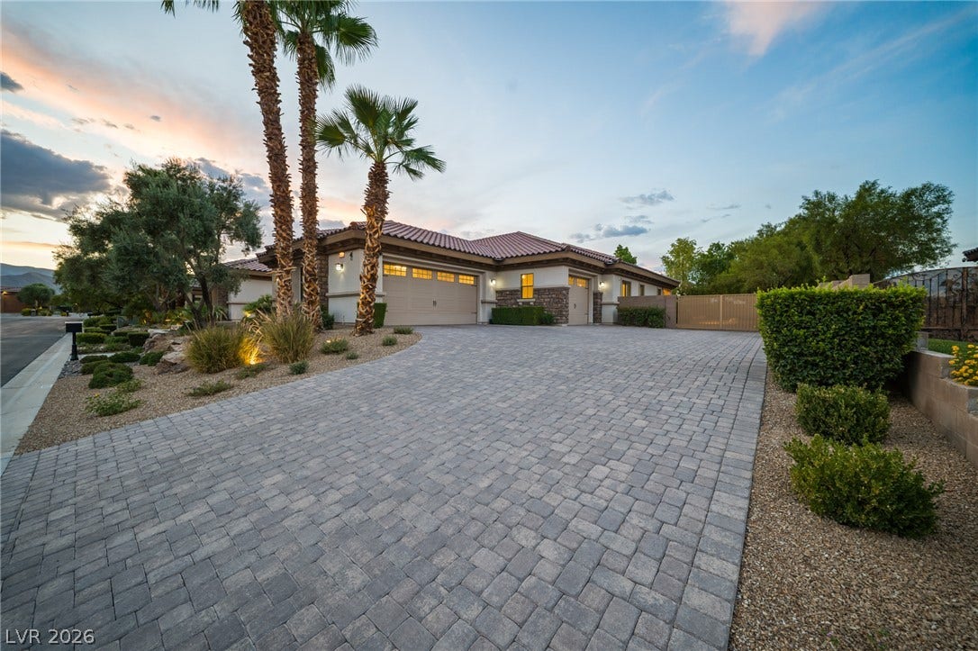 8030 Palm Cove Court, Las Vegas, NV 89129 An elegant paver driveway leads to the garage of this desert-landscaped single-story home.