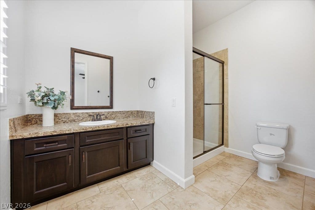 8030 Palm Cove Court, Las Vegas, NV 89129 En Suite Bathroom #4. Rich wood cabinetry matches the granite vanity top in this well-appointed bathroom.