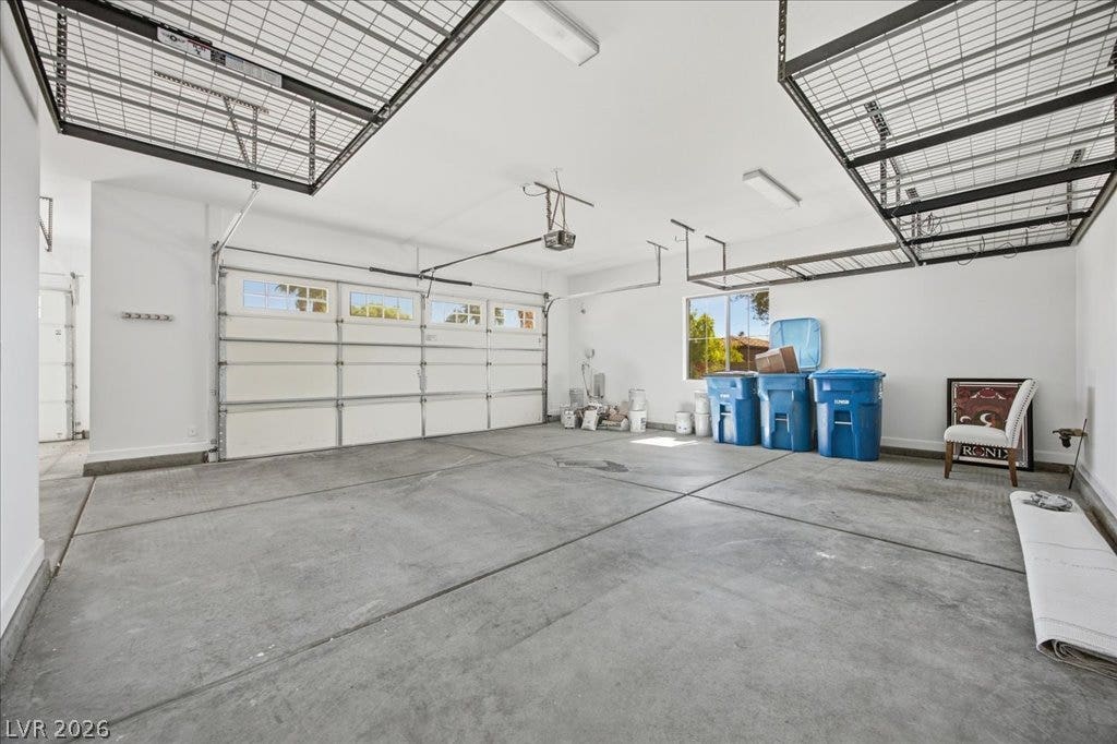 8030 Palm Cove Court, Las Vegas, NV 89129 An expansive garage space features poured concrete flooring and overhead storage racks.