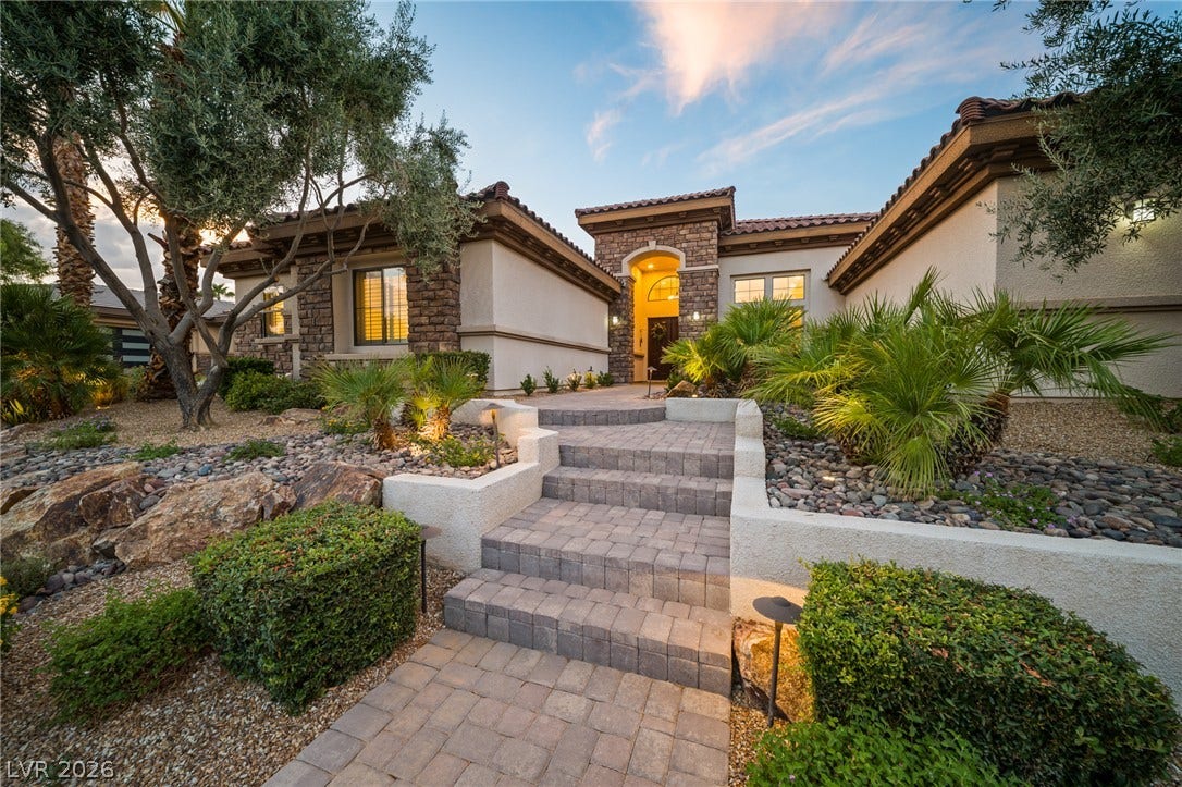 8030 Palm Cove Court, Las Vegas, NV 89129 Inviting stone-accented architecture framed by meticulous desert landscaping and stone paver pathways.