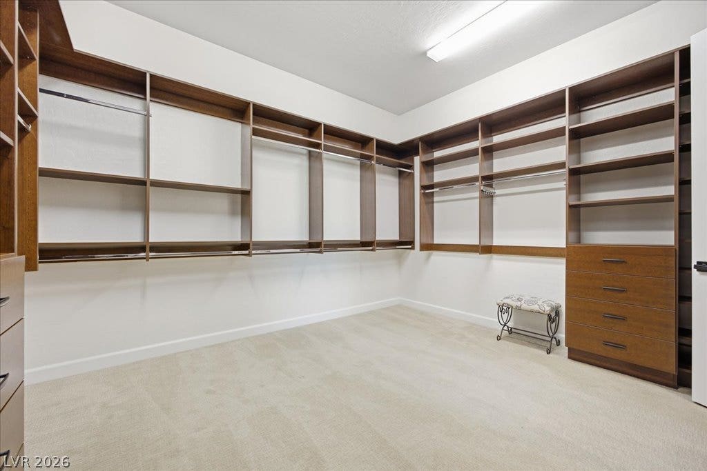 8030 Palm Cove Court, Las Vegas, NV 89129 Custom wood shelving and built-in dressers line this spacious walk-in closet with plush carpeting.