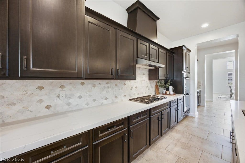 8030 Palm Cove Court, Las Vegas, NV 89129 Rich dark cabinetry pairs beautifully with stone countertops in this modern cooking space.