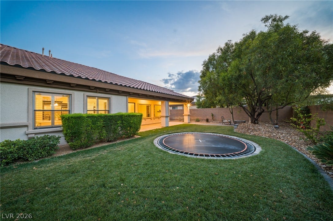 8030 Palm Cove Court, Las Vegas, NV 89129 Manicured lawn and a covered patio define this inviting backyard space.