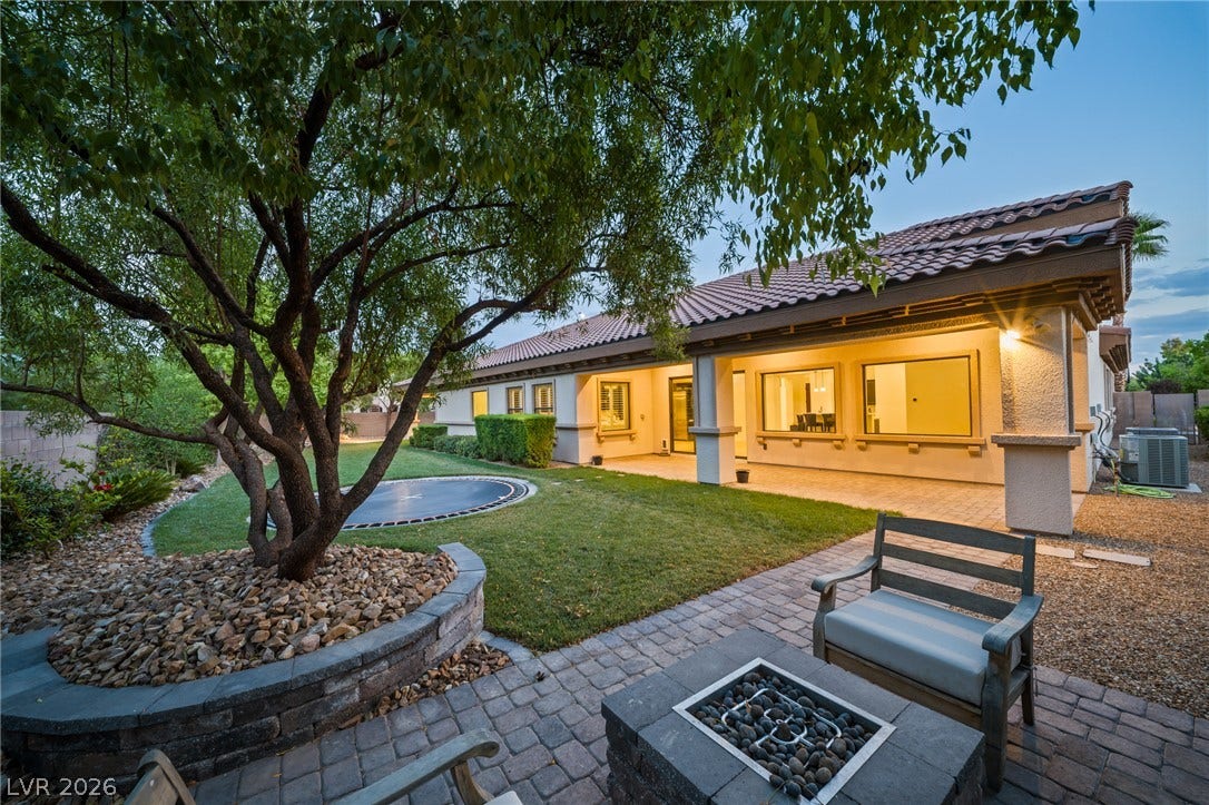 8030 Palm Cove Court, Las Vegas, NV 89129 An inviting stone fire pit area overlooks the manicured lawn and covered back patio.