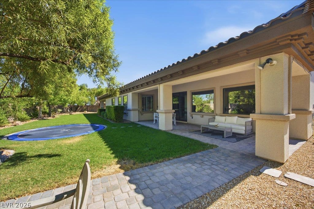 8030 Palm Cove Court, Las Vegas, NV 89129 An inviting covered patio overlooks the manicured green lawn and stone paved walkways.