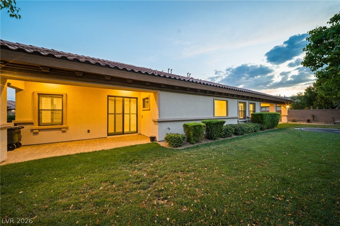 8030 Palm Cove Court, Las Vegas, NV 89129 A spacious grassy yard borders the covered back patio of this stucco-finished home.