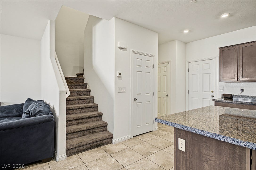 1180 Gypsum Hills Court, Henderson, NV 89002 Polished tile flooring and an open layout seamlessly connect the kitchen and carpeted staircase.