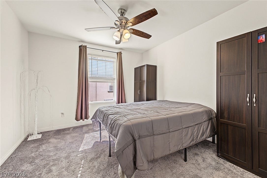 1180 Gypsum Hills Court, Henderson, NV 89002 Plush carpeting underfoot and a tall window define this comfortable, airy bedroom space.