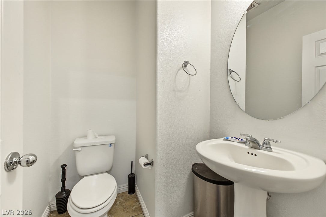 1180 Gypsum Hills Court, Henderson, NV 89002 A crisp pedestal sink and clean-lined finishes define this functional powder room space.