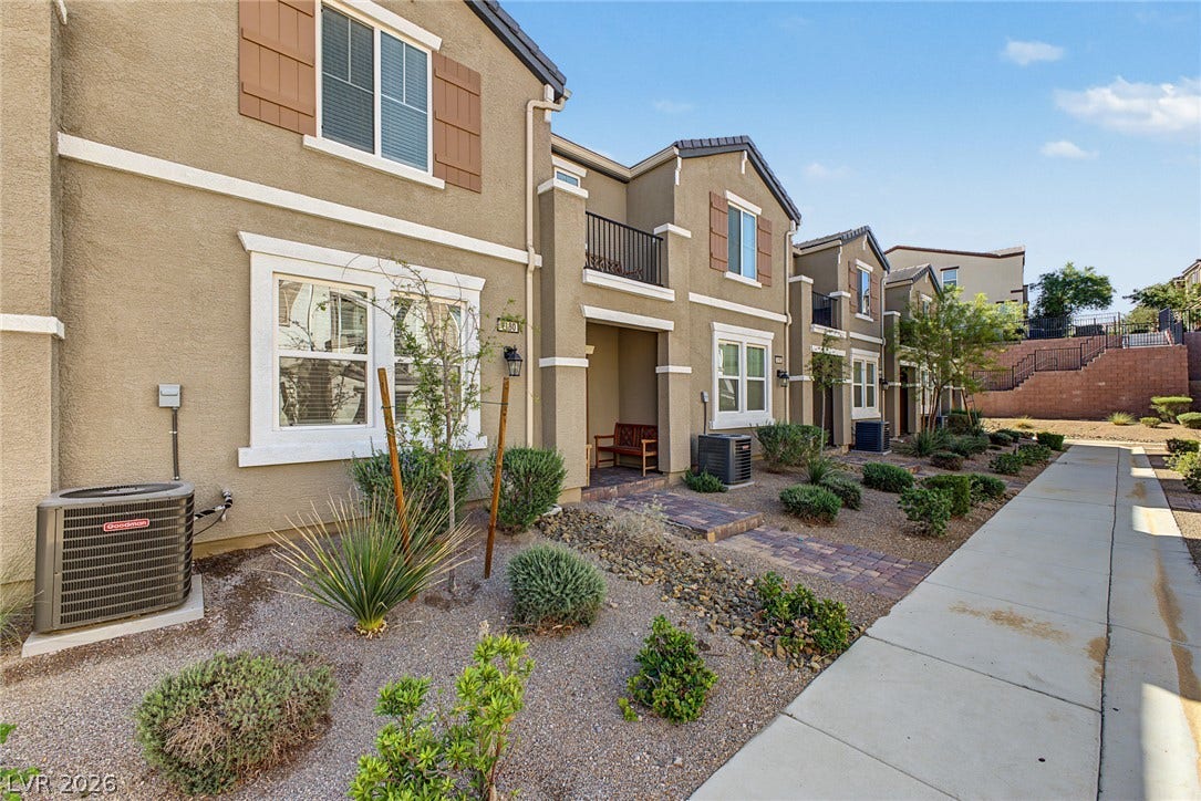 1180 Gypsum Hills Court, Henderson, NV 89002 Neat stucco exteriors line a paved walkway surrounded by desert landscaping.