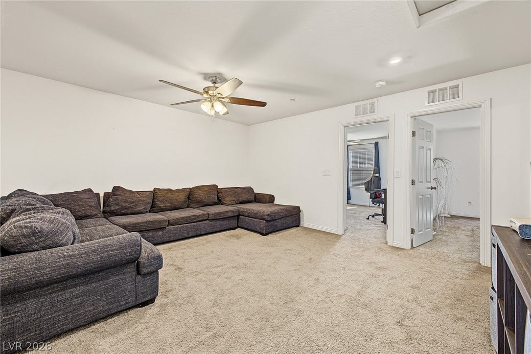1180 Gypsum Hills Court, Henderson, NV 89002 Soft carpeting underfoot anchors this versatile upstairs living space with clean white walls.