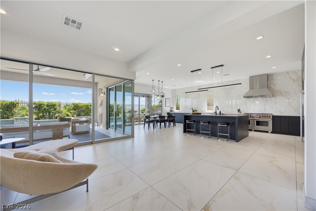 446 Bosco Di Fiore Street, Las Vegas, NV 89138 Sleek tile flooring and expansive sliding glass doors define this open architectural living space.