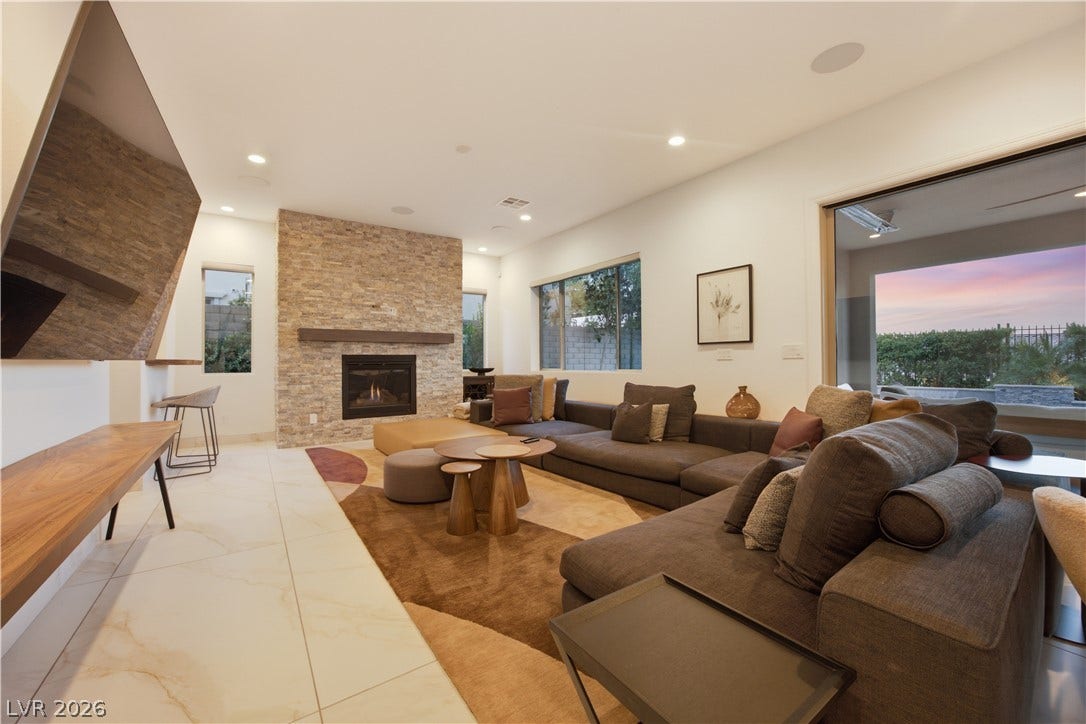 446 Bosco Di Fiore Street, Las Vegas, NV 89138 A floor-to-ceiling stone fireplace serves as the centerpiece of this spacious tiled living room.