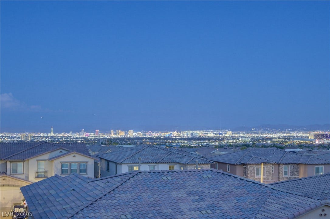 446 Bosco Di Fiore Street, Las Vegas, NV 89138 Glimmering city lights stretch across the horizon beneath a deep evening sky.