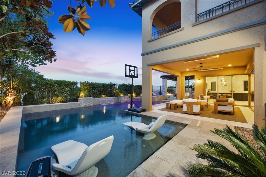 446 Bosco Di Fiore Street, Las Vegas, NV 89138 An inviting backyard oasis features a pristine swimming pool alongside a covered stone patio.