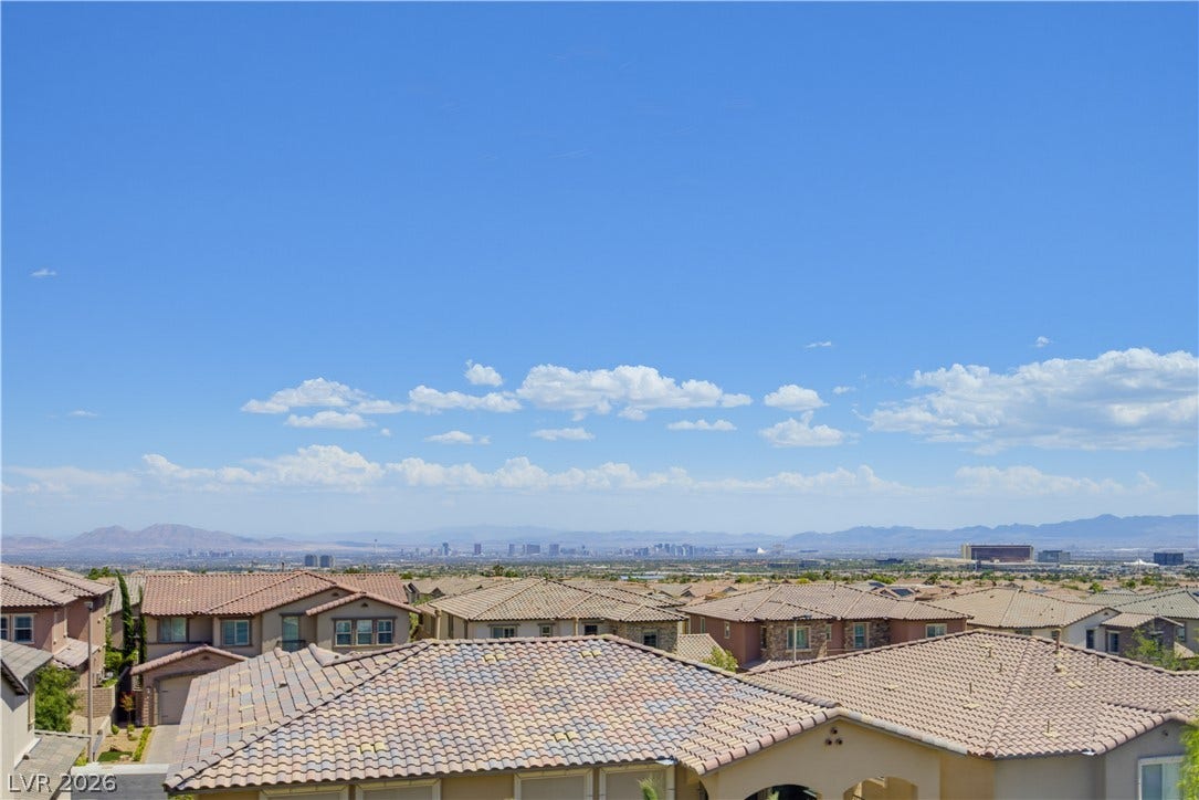 446 Bosco Di Fiore Street, Las Vegas, NV 89138 Distant city skyline and mountain views stretch across the wide horizon under clear blue skies.