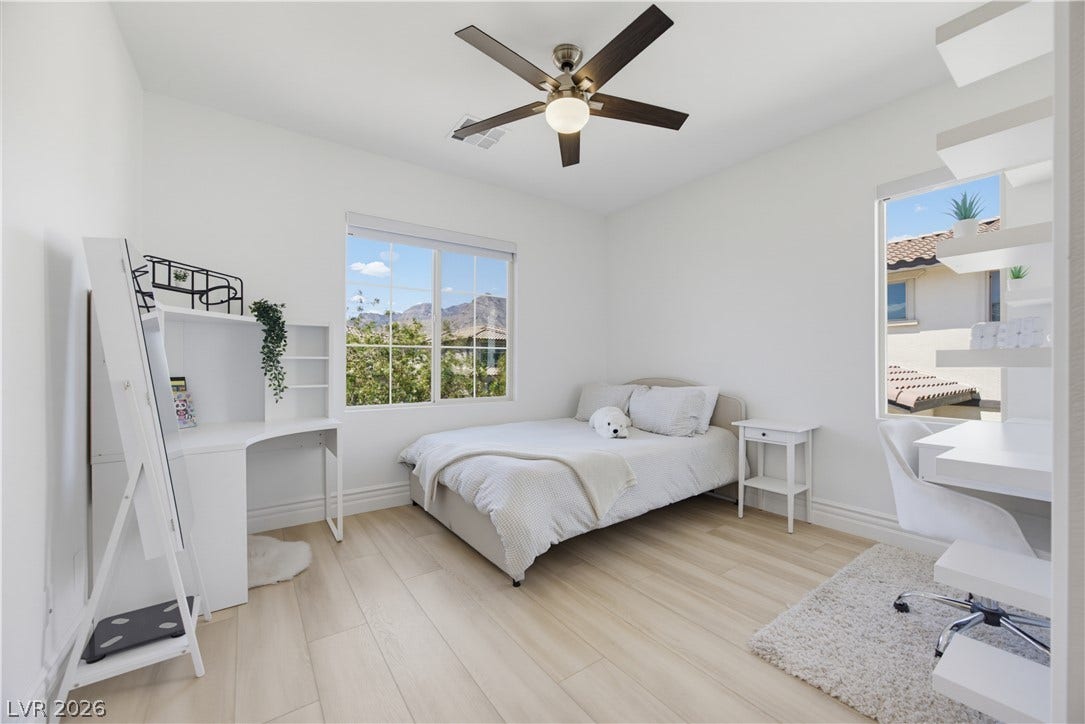 446 Bosco Di Fiore Street, Las Vegas, NV 89138 Clean lines and smooth wood floors define this tranquil bedroom under a high ceiling.