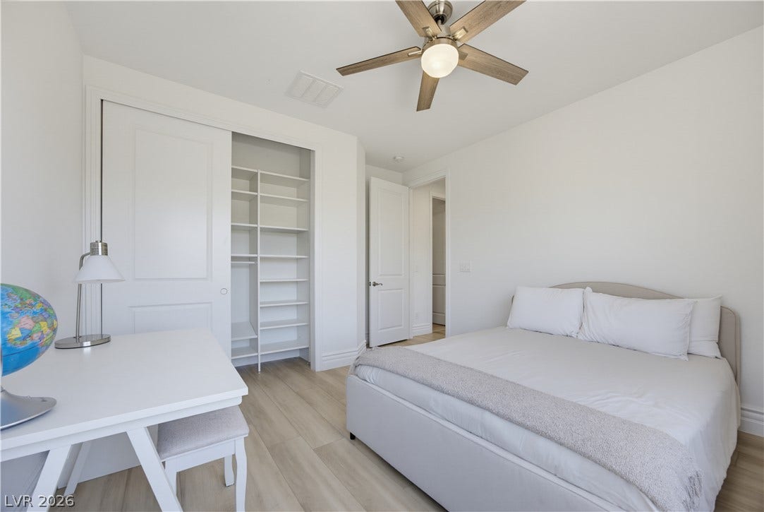 446 Bosco Di Fiore Street, Las Vegas, NV 89138 A spacious closet with built-in shelving complements the light wood-style flooring in this modern bedroom.