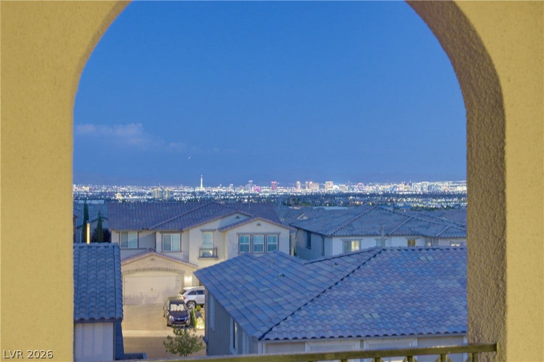446 Bosco Di Fiore Street, Las Vegas, NV 89138 An arched opening reveals a far-reaching vista of the glittering city skyline at dusk.