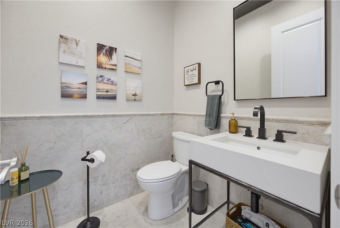 446 Bosco Di Fiore Street, Las Vegas, NV 89138 Half bath with Elegant stone wainscoting and tile flooring highlight this beautifully designed powder room.