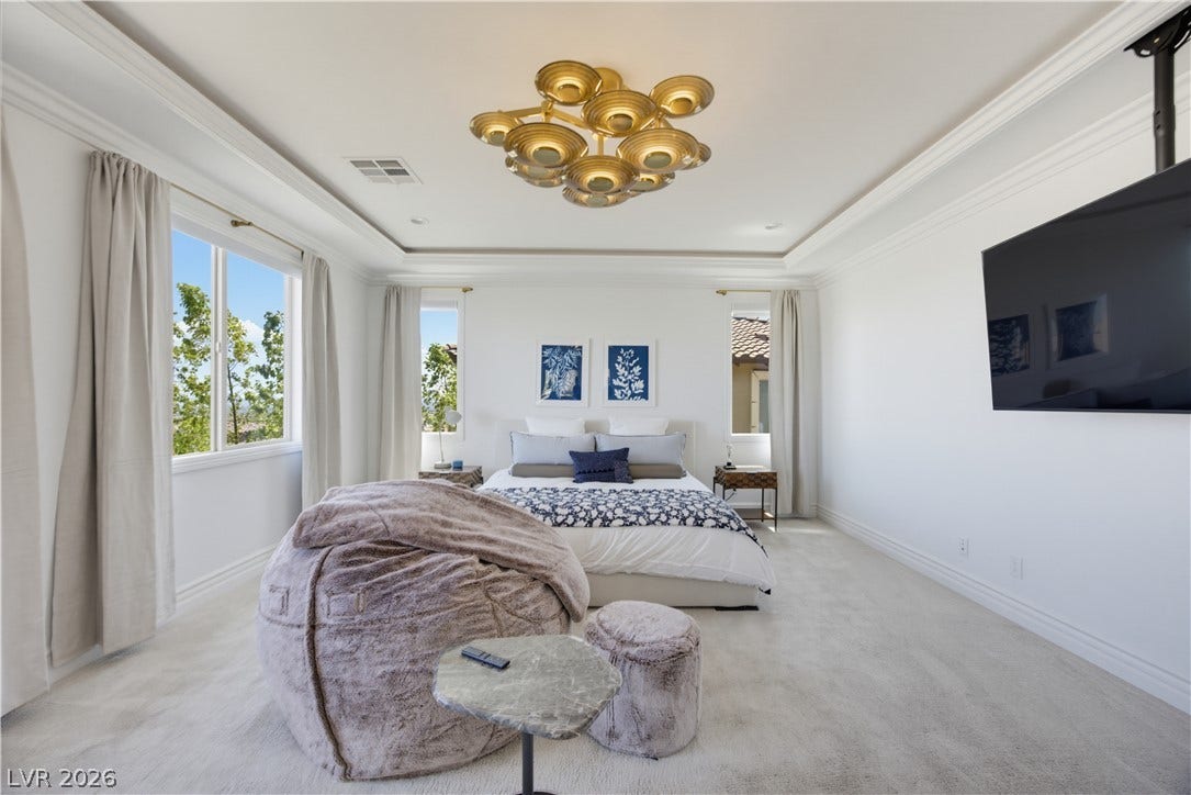 446 Bosco Di Fiore Street, Las Vegas, NV 89138 Crown molding and a tray ceiling define this elegant bedroom featuring plush carpet underfoot.