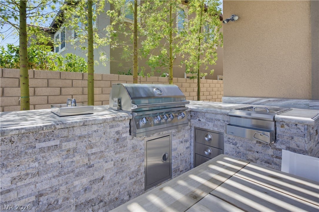 446 Bosco Di Fiore Street, Las Vegas, NV 89138 A stone-finished outdoor kitchen provides the perfect setup for backyard dining and entertaining.