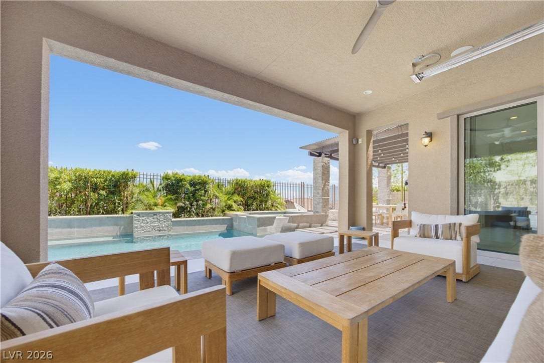 446 Bosco Di Fiore Street, Las Vegas, NV 89138 A covered patio overlooks a private pool area framed by manicured hedges.