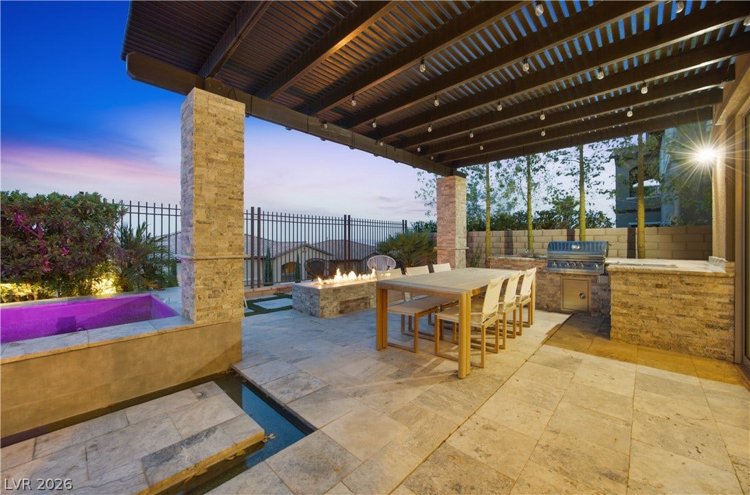 446 Bosco Di Fiore Street, Las Vegas, NV 89138 Stone tile flooring and a covered pavilion define this outdoor kitchen and dining area.