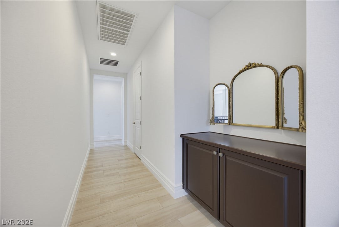 446 Bosco Di Fiore Street, Las Vegas, NV 89138 Recessed lighting and light-toned wood flooring enhance this clean, neutral hallway corridor.