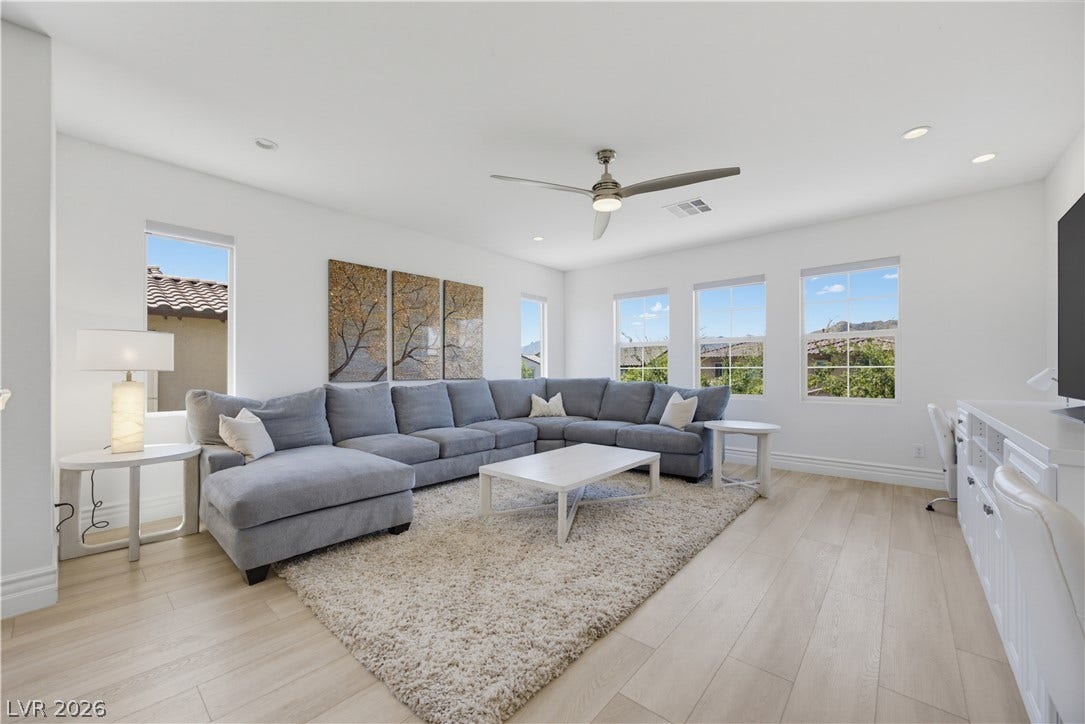 446 Bosco Di Fiore Street, Las Vegas, NV 89138 Generous windows frame neighborhood views in this bright living space with smooth wood floors.