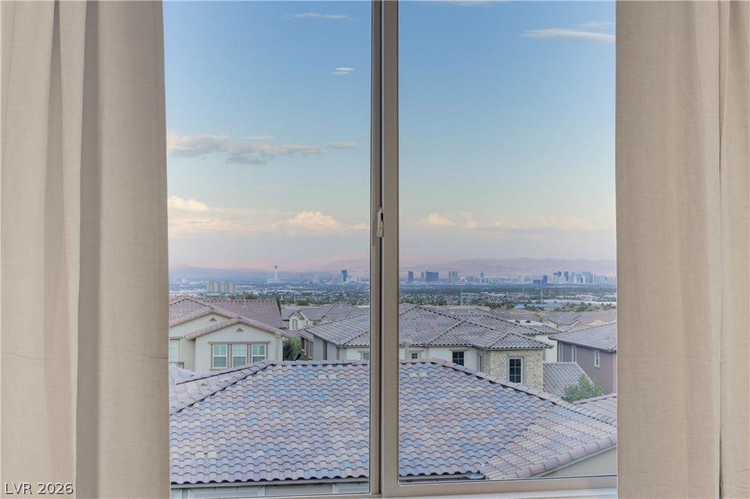 446 Bosco Di Fiore Street, Las Vegas, NV 89138 Vast mountain and distant city skyline vistas frame the view through a large window.