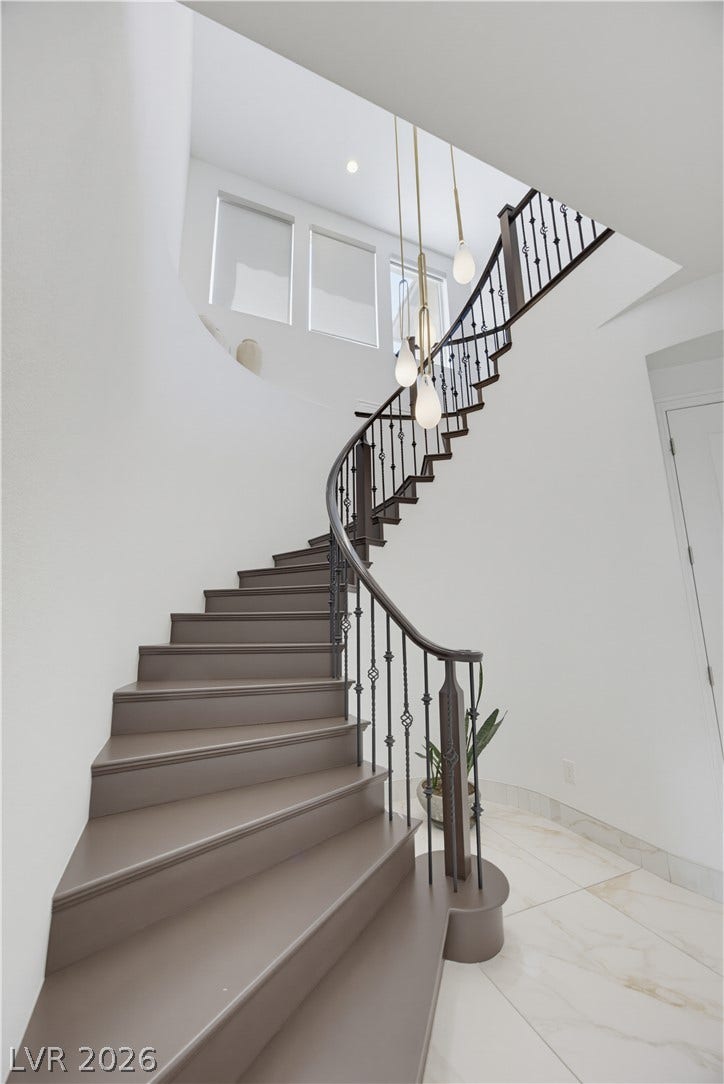 446 Bosco Di Fiore Street, Las Vegas, NV 89138 An elegant curved staircase anchors the soaring entryway with polished tile flooring.