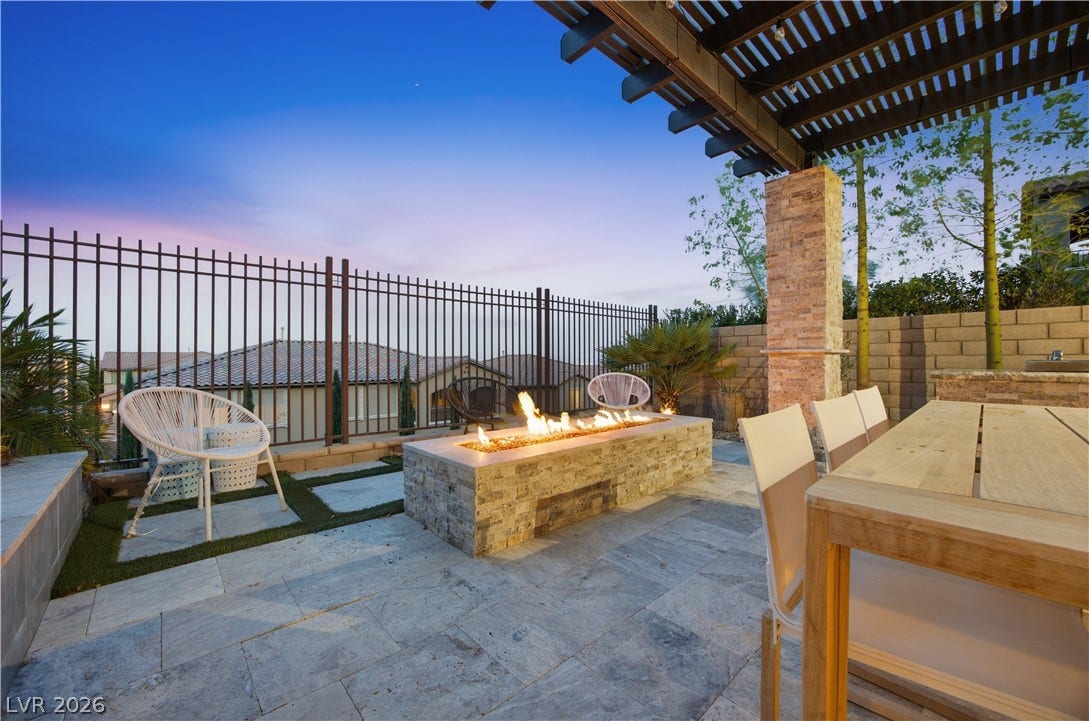 446 Bosco Di Fiore Street, Las Vegas, NV 89138 Stone pavers line this inviting outdoor terrace featuring a built-in fire pit under a pergola.