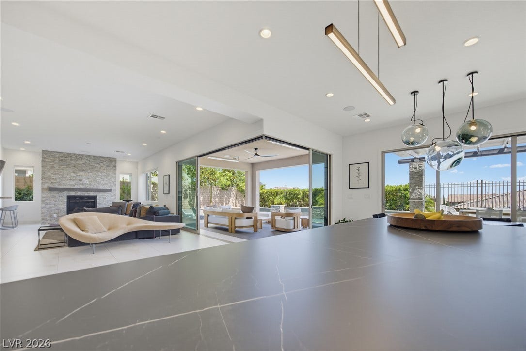 446 Bosco Di Fiore Street, Las Vegas, NV 89138 A seamless indoor-outdoor connection defines this modern living area with large glass doors.