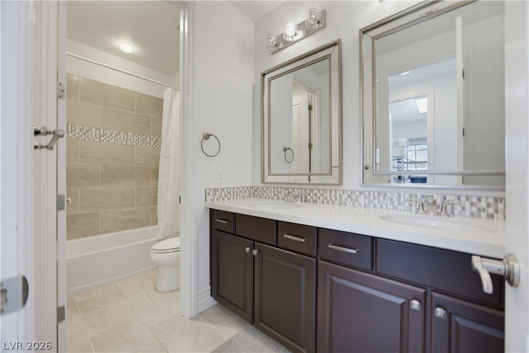 446 Bosco Di Fiore Street, Las Vegas, NV 89138 A spacious double vanity and custom tile tub surround define this modern bathroom.