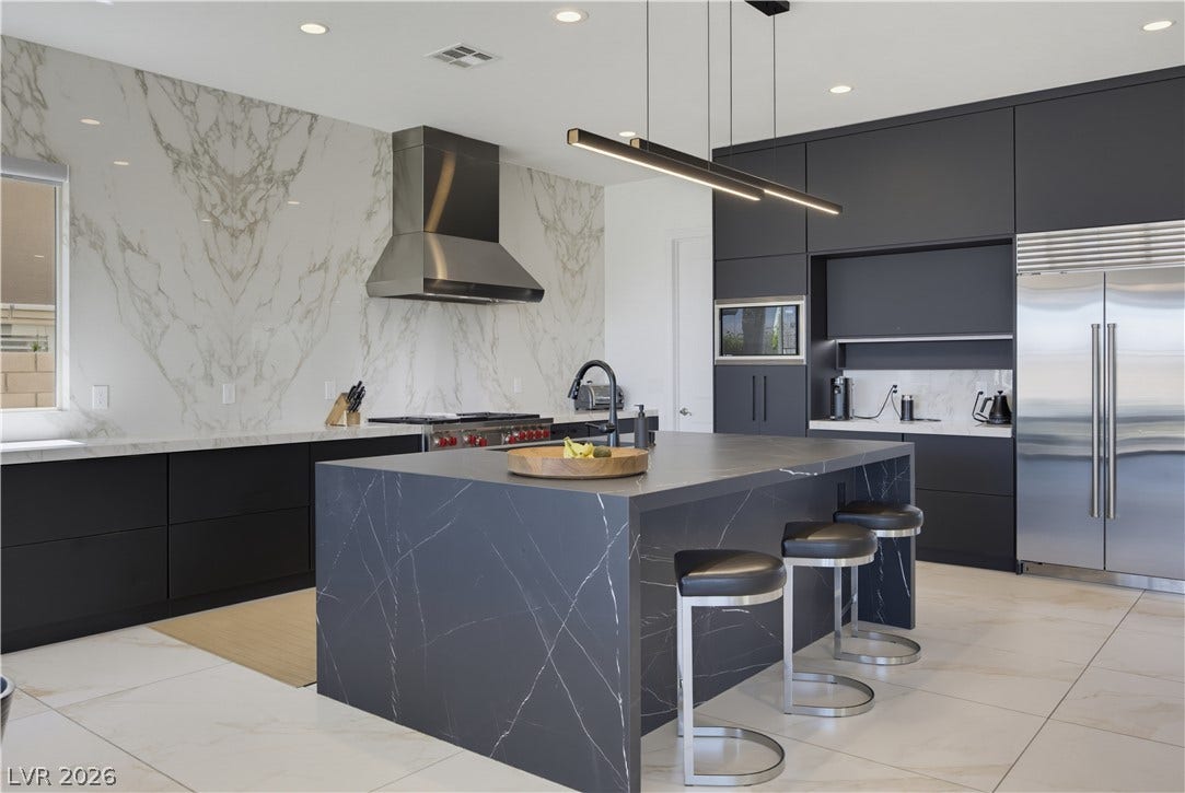 446 Bosco Di Fiore Street, Las Vegas, NV 89138 Dramatic dark cabinetry contrasts with striking stone surfaces in this contemporary culinary space.