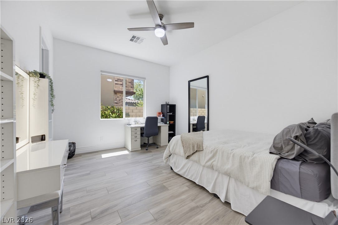 446 Bosco Di Fiore Street, Las Vegas, NV 89138 Downstairs bedroom with high ceilings and clean wood-look flooring enhance this light-filled private bedroom retreat.