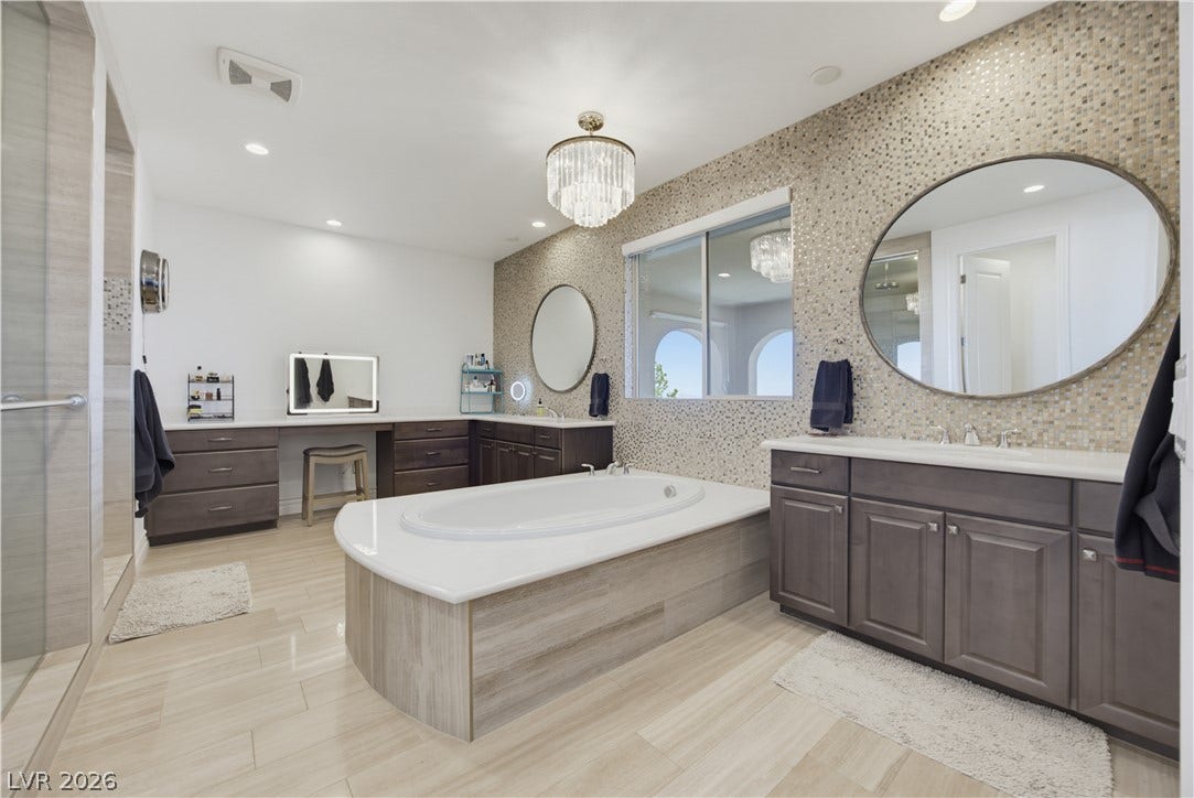 446 Bosco Di Fiore Street, Las Vegas, NV 89138 An integrated soaking tub highlights this bathroom featuring dual vanities and modern tile accents.