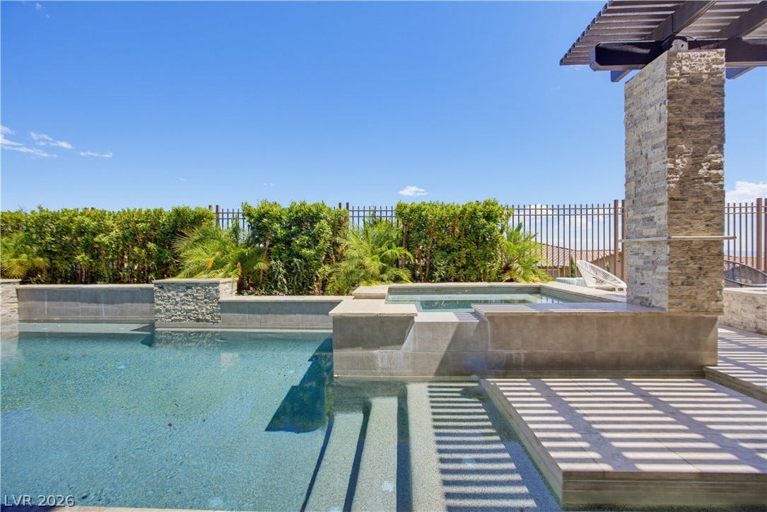 446 Bosco Di Fiore Street, Las Vegas, NV 89138 An inviting swimming pool and integrated spa sit beneath a clear blue sky.