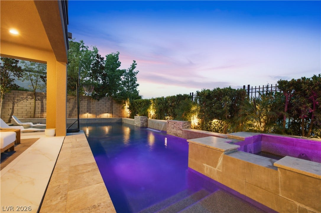 446 Bosco Di Fiore Street, Las Vegas, NV 89138 A sparkling swimming pool and integrated spa sit adjacent to a sheltered stone patio.