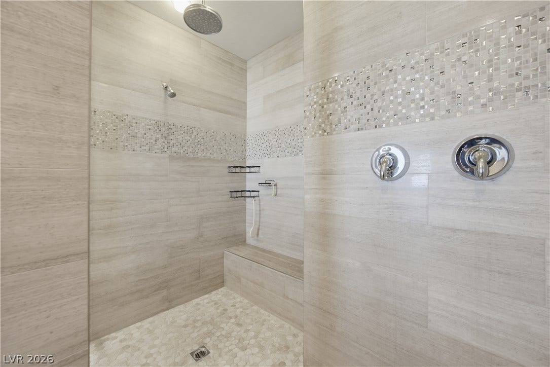 446 Bosco Di Fiore Street, Las Vegas, NV 89138 Custom tile work and a built-in bench elevate this spacious walk-in shower design.