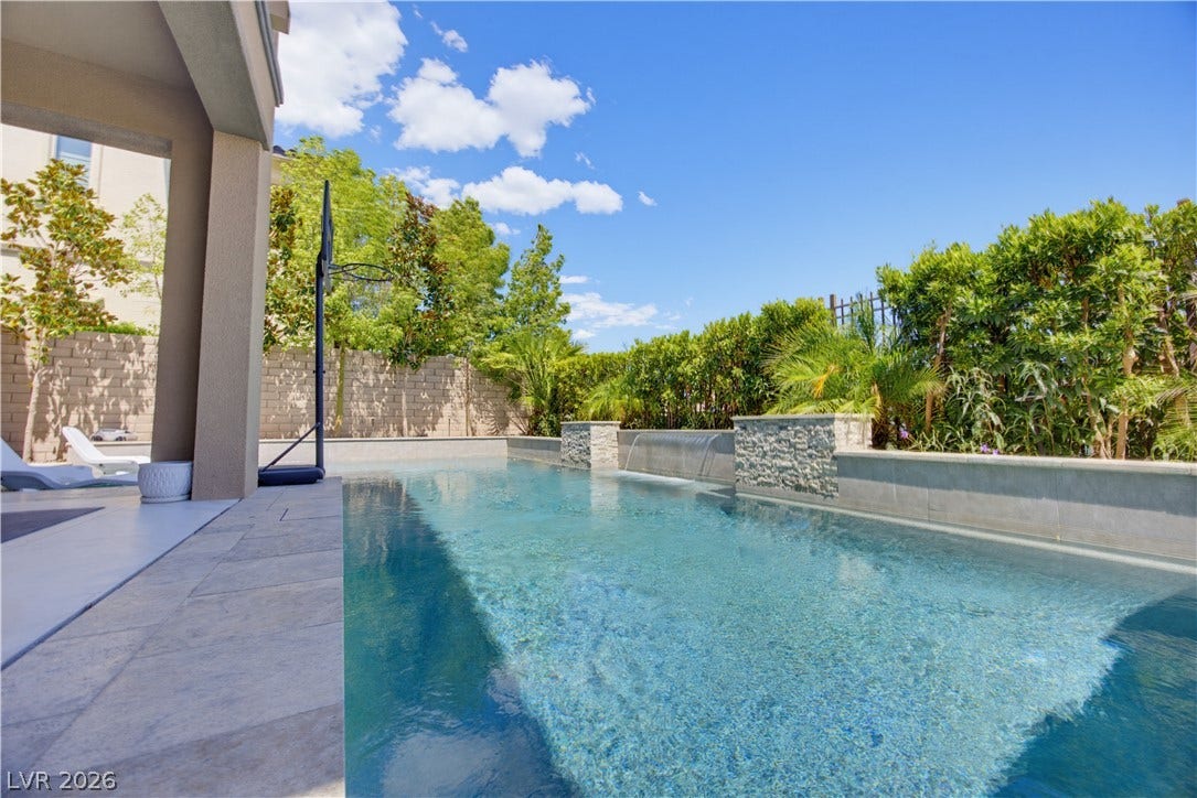 446 Bosco Di Fiore Street, Las Vegas, NV 89138 An inviting swimming pool features stone waterfall accents alongside a tiled lounging patio.