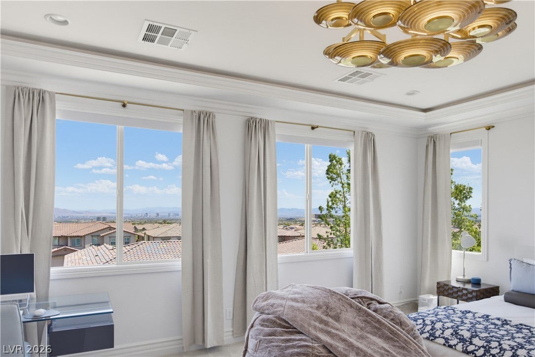 446 Bosco Di Fiore Street, Las Vegas, NV 89138 Large picture windows frame elevated neighborhood and skyline views from this spacious bedroom.