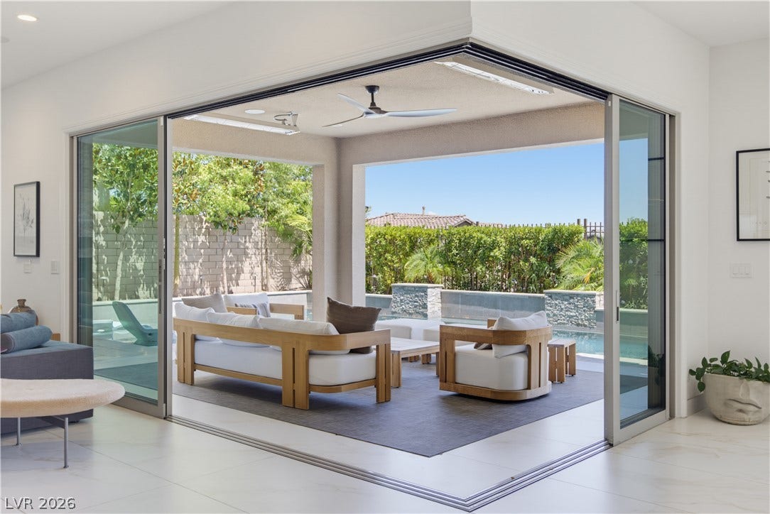 446 Bosco Di Fiore Street, Las Vegas, NV 89138 Retractable glass doors merge interior living space with a covered patio and pool view.