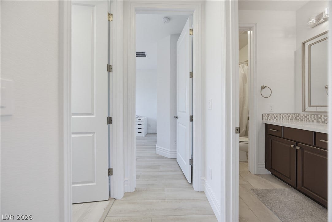 446 Bosco Di Fiore Street, Las Vegas, NV 89138 A light-filled hallway features wood-look tile flooring and provides access to adjacent rooms.