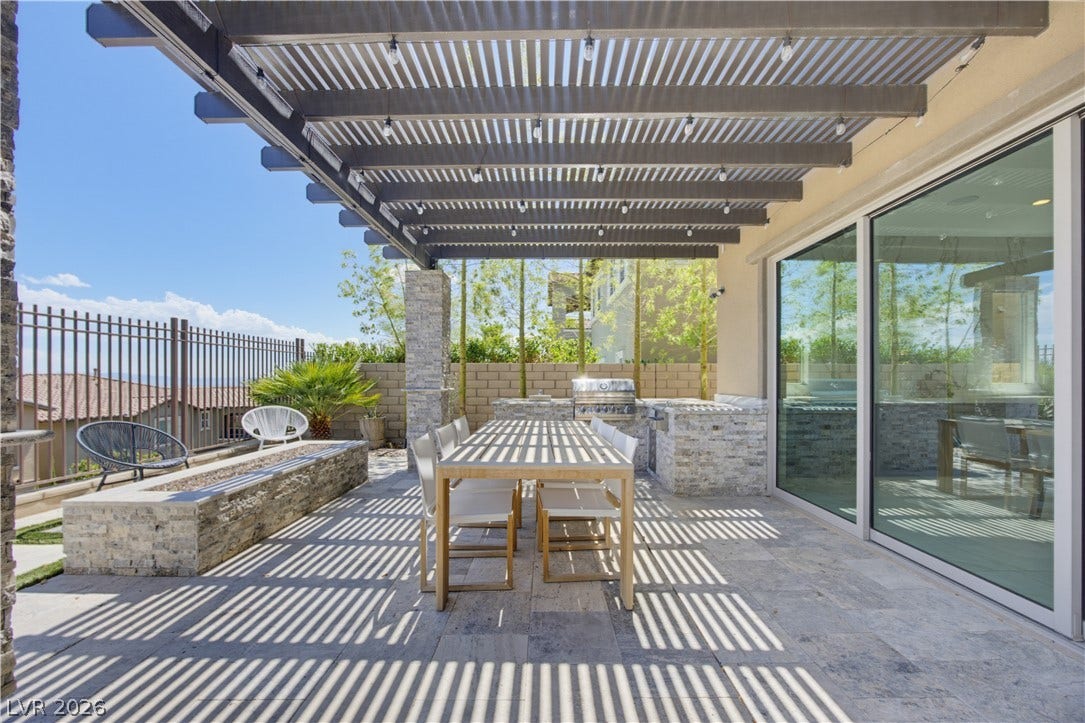 446 Bosco Di Fiore Street, Las Vegas, NV 89138 An inviting outdoor kitchen and dining terrace rests beneath a custom louvered pergola.