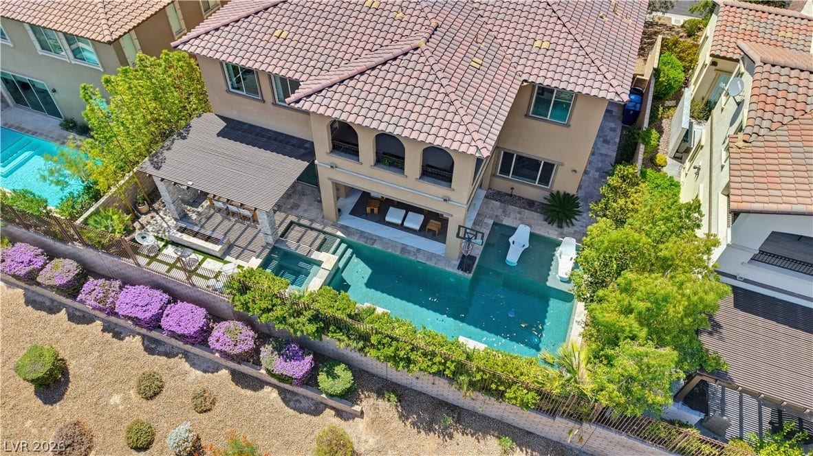 446 Bosco Di Fiore Street, Las Vegas, NV 89138 An inviting backyard oasis features a swimming pool, spa, and covered outdoor living area.