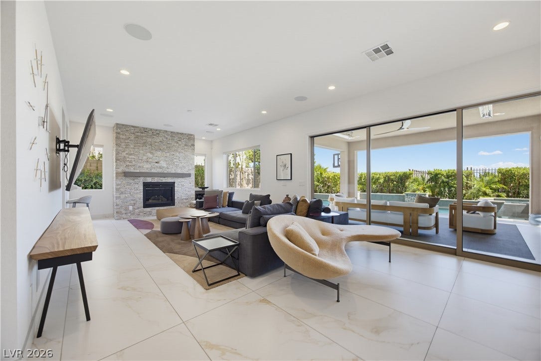 446 Bosco Di Fiore Street, Las Vegas, NV 89138 Polished tile flooring and a stacked-stone fireplace define this airy living space.